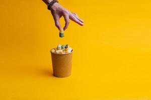 cans of paint on a colored background, shades of green, sweet corn lying in a can of paint, top view, minimalism concept, object on a yellow background close-up photo