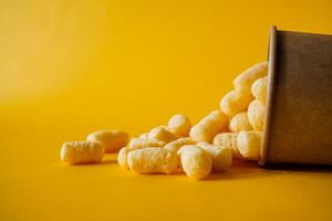 cans of paint on a colored background, shades of green, sweet corn lying in a can of paint, top view, minimalism concept, object on a yellow background close-up photo