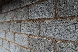 cinder blocks of gray concrete are neatly stacked in a pile, slender rows of bricks, material for building a house photo