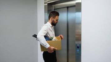 Dismissed worker with dismissal box getting into the elevator. Dismissal from work video