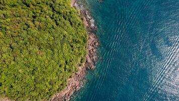 Verdant Coastline Meets Tranquil Azure Sea photo