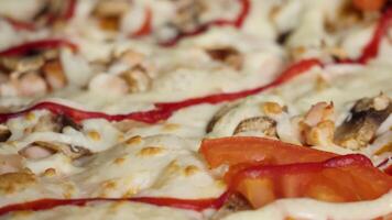 pizza bakgrund, ost stänga upp. ram. färsk pizza i makro se. pizza med mozzarella, skinka, halverad körsbär tomater, kapris, kryddor och färsk basilika. italiensk pizza. Hem tillverkad mat. begrepp för en video