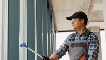 ásia masculino profissional limpeza serviço trabalhador limpa a janelas e fazer compras janelas do uma loja com especial equipamento video