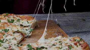 måltid tid på pizzeria, man tar en skiva av de pizza skott med mycket tunn djup av fält. ram. hand skära skiva av pizza och ta Det, stänga upp, makro skott. pizza och skiva av pizza i hand på de video