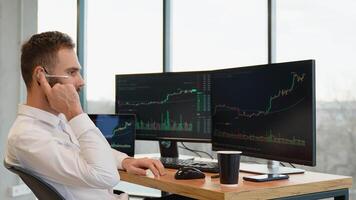 Concentrated crypto trader sitting in front of computers, making professional analysis of candlestick chart, creating strategy video