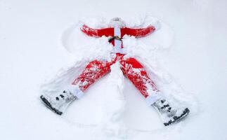 Papa Noel claus hace nieve ángeles en el nieve. humor, invierno divertido, Papa Noel es cansado y borracho foto