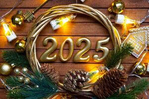 New Year House key with keychain cottage on festive brown wooden background with number 2025 in wreath, lights of garlands. Purchase, construction, relocation, mortgage, insurance photo