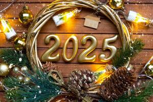 New Year House key with keychain cottage on festive brown wooden background with number 2025 in wreath, lights of garlands. Purchase, construction, relocation, mortgage, insurance photo
