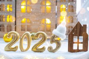 dorado cifras número 2025 y minúsculo hogar en antecedentes de acogedor ventanas de un casa con calentar ligero con festivo decoración de estrellas, nieve y guirnaldas saludo tarjeta, contento nuevo año, acogedor hogar foto