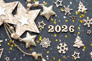 Happy New Year-wooden letters and the numbers 2026 on festive black background with sequins, stars, snow. Greetings, postcard. Calendar, cover photo