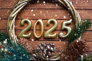 Happy New Year golden numbers 2025 on cozy festive brown wooden background with sequins, snow, lights of garlands. Greetings, postcard. Calendar, cover photo