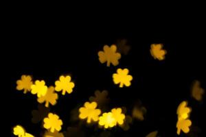 glare, bokeh, lights in the shape of clover leaves on a black background. for overlay photo