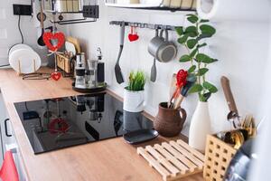 The interior of the kitchen in the house is decorated with red hearts for Valentine's Day. Decor on the table, stove, utensils, festive mood in a family nest photo