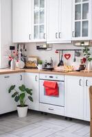 el interior de la cocina de la casa está decorado con corazones rojos para el día de san valentín. decoración en la mesa, estufa, utensilios, ambiente festivo en un nido familiar foto