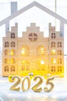 Golden figures number 2025 against the background of cozy windows of a house with warm light with festive decor of stars,snow and garlands. Greeting card, Happy New Year, cozy home photo