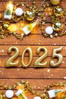 Happy New Year wooden numbers 2025 on cozy festive brown wooden background with sequins, snow, lights of garlands. Greetings, postcard. Calendar, cover photo