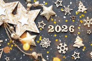 Happy New Year-wooden letters and the numbers 2026 on festive black background with sequins, stars, snow. Greetings, postcard. Calendar, cover photo