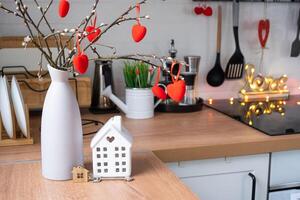 llave a minúsculo casa de acogedor hogar con enamorado decoración en mesa de cocina. regalo para san valentin día, familia amor nido. diseño, proyecto, Moviente a nuevo casa, hipoteca, alquilar y compra real inmuebles foto