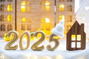 Golden figures number 2025 and tiny home on background of cozy windows of a house with warm light with festive decor of stars,snow and garlands. Greeting card, Happy New Year, cozy home photo