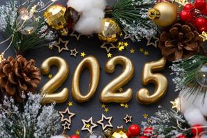 el dorado cifras 2025 hecho de velas en un negro Roca pizarra antecedentes son decorado con un festivo decoración de estrellas, lentejuelas, abeto sucursales, pelotas y guirnaldas saludo tarjeta, contento nuevo año. foto