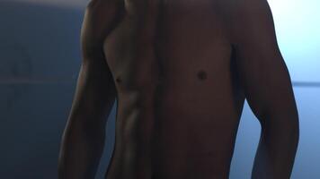 Half-length portrait of nude boxer with hands on hips, on dark background with light, close up. Young handsome male fighter standing concentrated before fight with putting palms together video