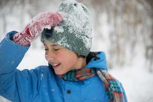 un chico en un Nevado parque. foto de un adolescente en un invierno bosque. invierno, invierno vacaciones, vacaciones, vacaciones
