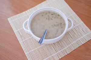 Mung Bean Porridge or Bubur Kacang Hijau, Indonesian dessert porridge of mung beans with coconut milk, pandan leaf and ginger. Served in bowl. photo