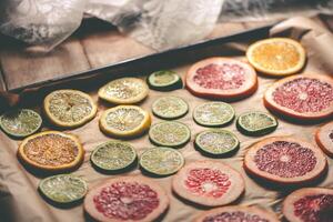 Sliced orange, tangerine and grapefruit slices on baking sheet, preparing citrus wedges for Christmas garland photo