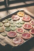Sliced orange, tangerine and grapefruit slices on baking sheet, preparing citrus wedges for Christmas garland photo