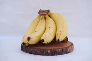 Bunch of bananas on a wooden stand on a white background. photo