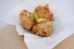 Bakwan sayur or vegetable fritter, Indonesian snack made from flour, cabbage, carrots and bean sprouts, served with chili photo