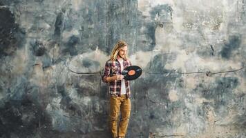 AI generated A man with long hair, holding a vinyl record, stands against a textured, grunge-style backdrop. photo