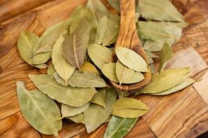 Bay leaves and on olive wood photo