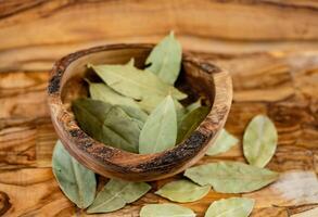 Bay leaves and on olive wood photo