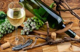 blanco vino uvas en aceituna madera foto