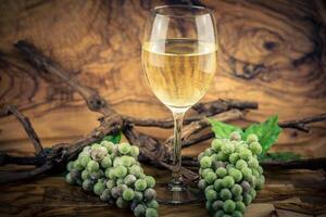 blanco vino uvas en aceituna madera foto