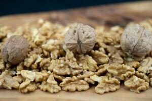 Fresh and cracked walnuts on olive wood photo