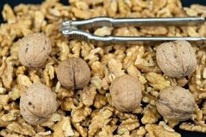 Fresh and cracked walnuts on olive wood photo