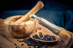 a stack of peppercorns on olive wood photo