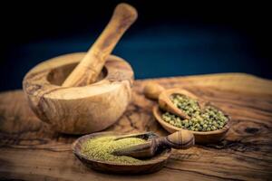 a stack of peppercorns on olive wood photo