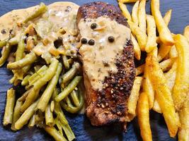 french Peppersteak with green Pepper  green beans and pommes frites photo