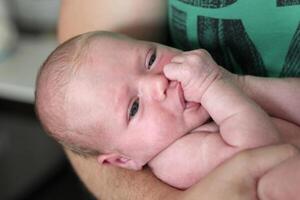 retrato de un recién nacido bebé en el brazos de papá foto