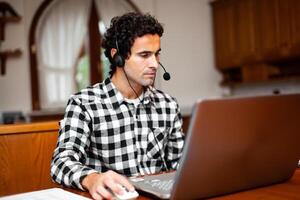 Guy using headset and laptop computer, teleworking concept photo