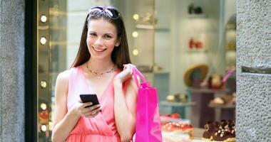 joven mujer utilizando su teléfono inteligente mientras compras en un ciudad foto