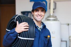 retrato de un sonriente trabajador que lleva acanalado conducto foto