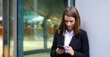 Smiling businesswoman using a smartphone outdoor photo