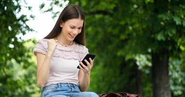 muy contento mujer leyendo bueno Noticias vía su teléfono inteligente - victoria concepto foto