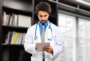 Doctor checking his tablet in his studio photo