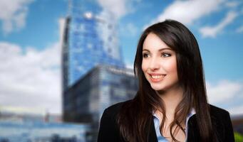 Businesswoman portrait outdoor against a modern city skyline in the background photo
