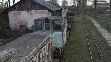 Aerial view of old rusty locomotives of a narrow gauge railway. Abandoned railway depot. 4K video